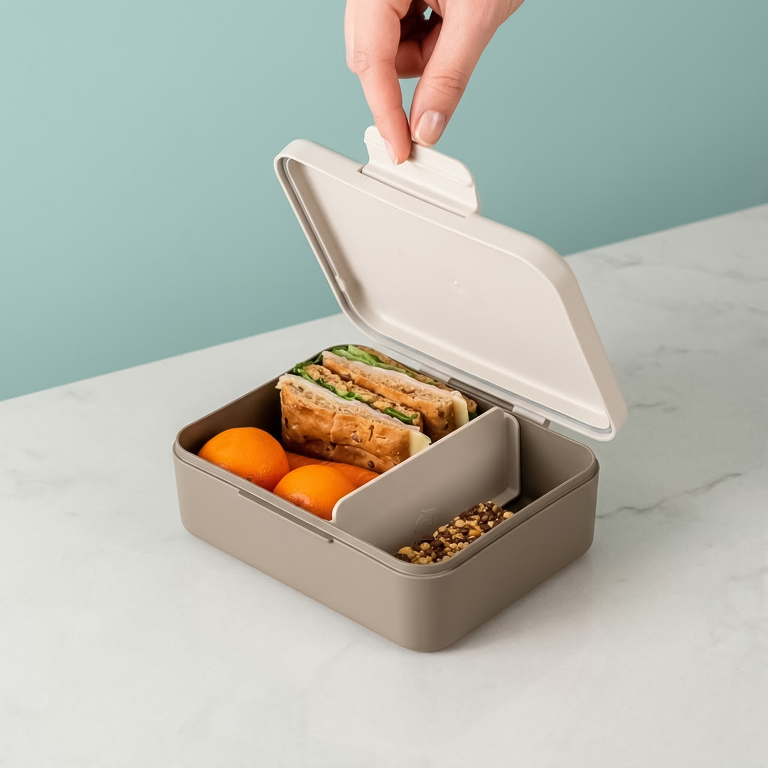 sand color lunch box with orange and a sandwich