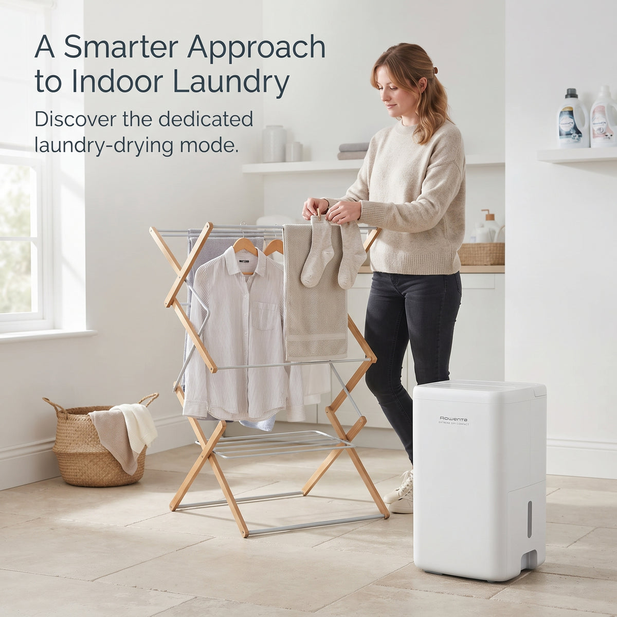 Portable 14L dehumidifier running laundry drying mode next to a clothes airer for fast indoor drying.
