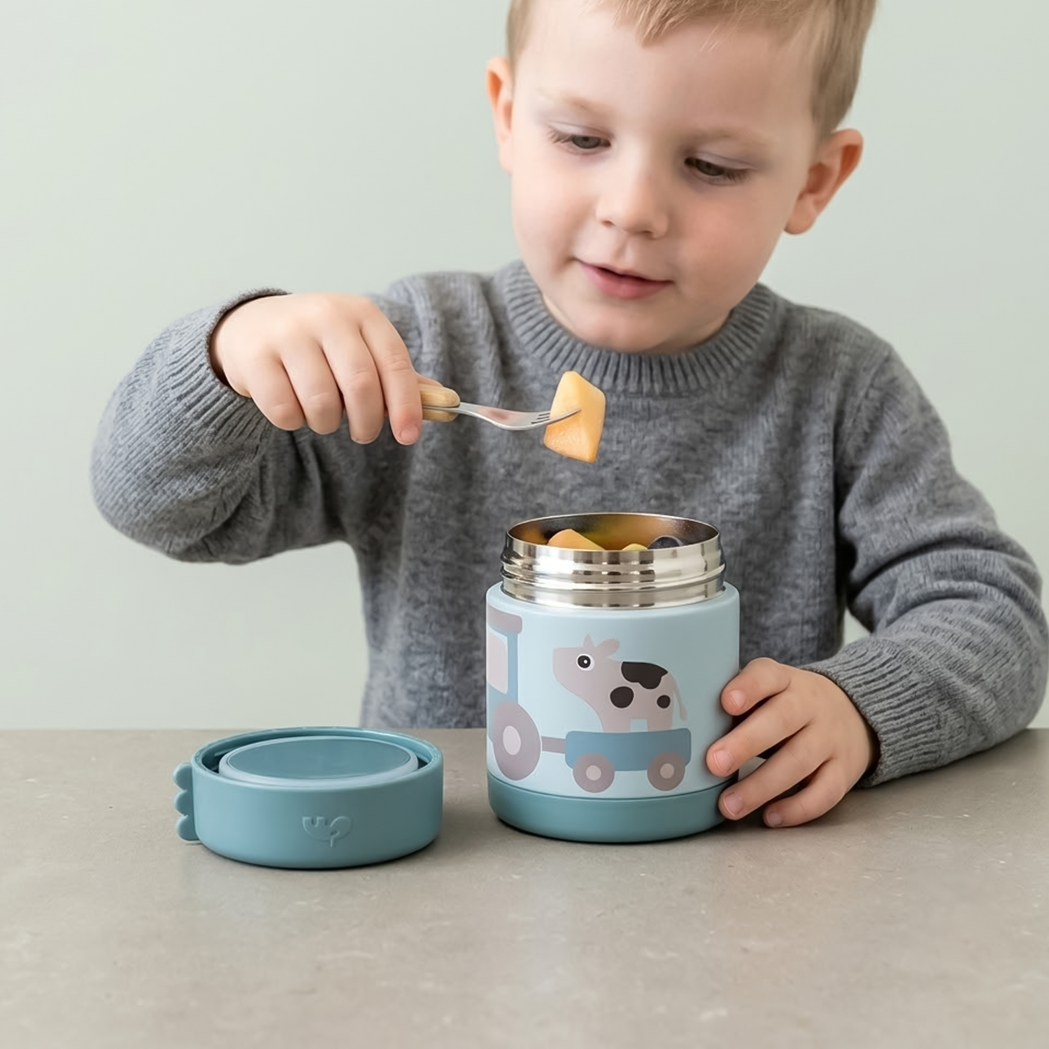kid eating fruit with fork 