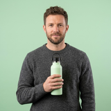 man holding light green bottle