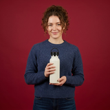 woman holding white colored bottle in  dark red background